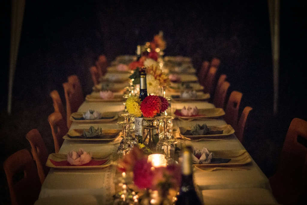 Long candlelit dinner table with flowers